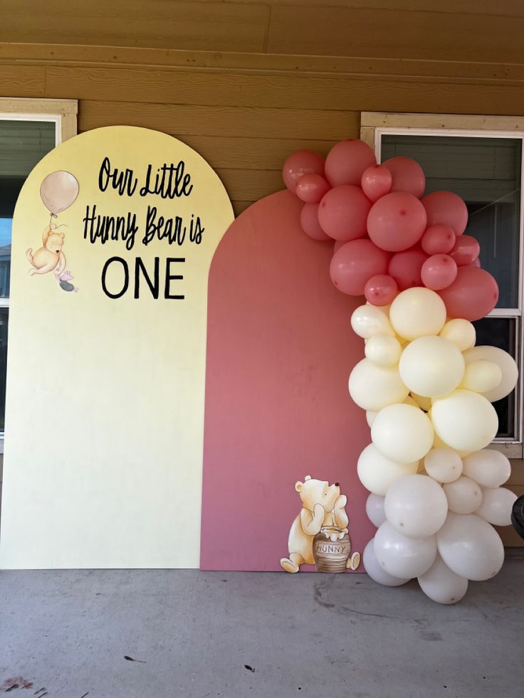 a balloon arch with winnie the pooh balloons