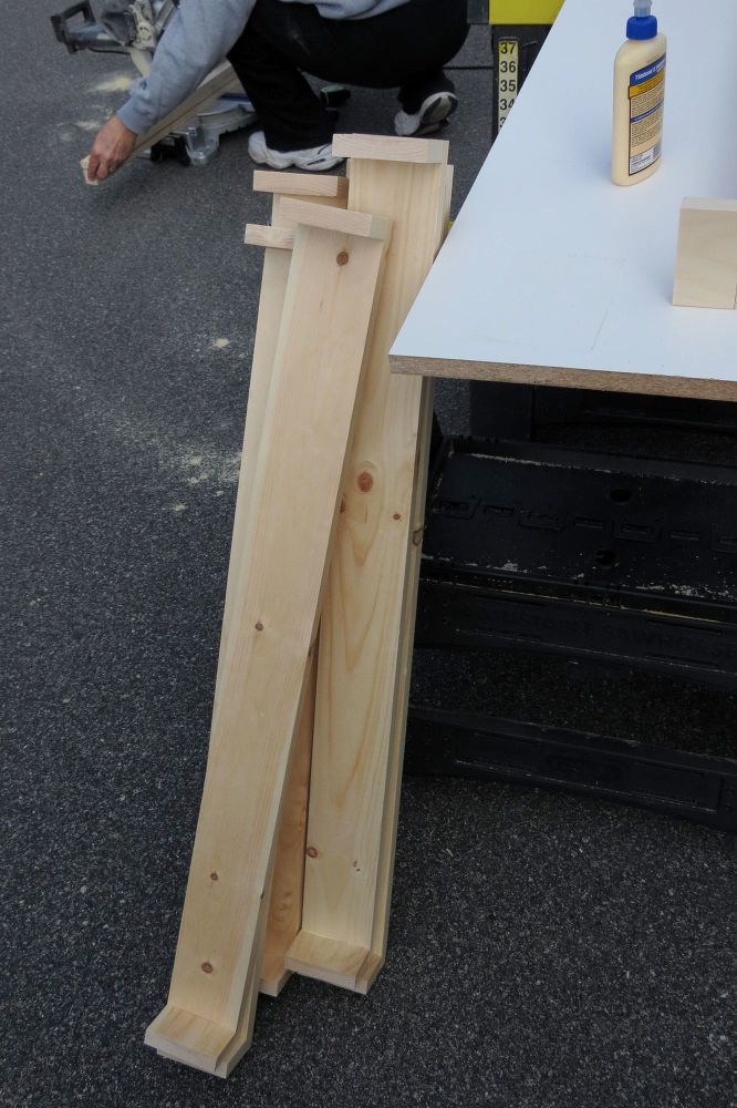 a man kneeling down next to a table that is made out of plywood