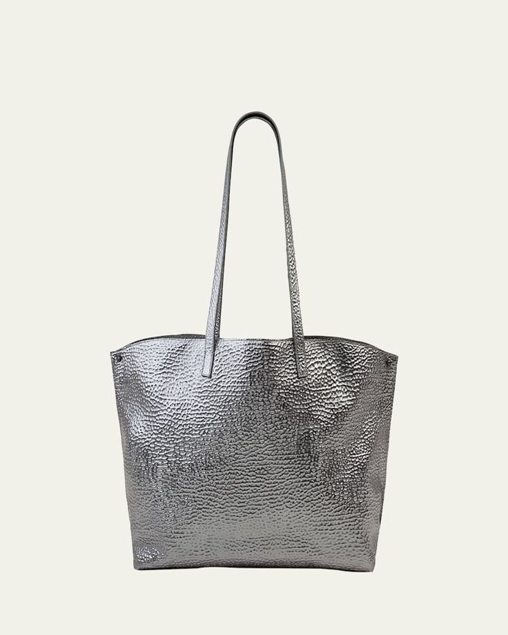 Akris metallic shoulder bag in hammered leather. Approx. 18.50"H x 12.20"W x 5.12"D; 11.42" drop. Two flat shoulder straps. Open top. Folded sides secure at turnlock front. Interior, two zip pockets. "AI" is imported. Formal Top Handle Shoulder Bag With Grained Texture, Formal Grained Texture Top Handle Shoulder Bag, Metallic Rectangular Shoulder Bag For Travel, Formal Rectangular Bag With Grained Texture, Formal Rectangular Bags With Grained Texture, Formal Bags With Grained Texture, Rectangular Bags With Grained Texture For Daily Use, Grained Texture Shoulder Bag, Modern Formal Shoulder Bag With Grained Texture