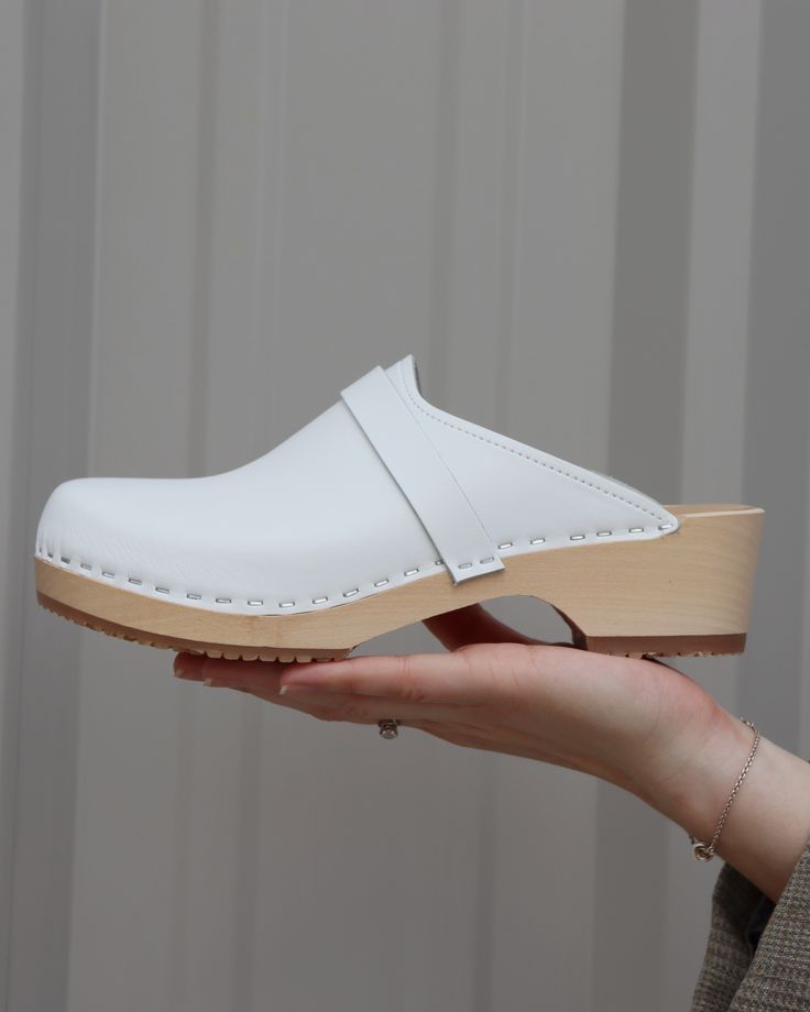 Handmade clog from Sweden. Light wooden base, Snow white leather. White Round Toe Clogs For Winter, Comfortable White Winter Clogs, Classic White Round Toe Clogs, Classic White Closed Toe Clogs, Classic White Clogs With Cushioned Footbed, Classic White Clogs With Rubber Sole, White Clogs, Wooden Base, White Leather