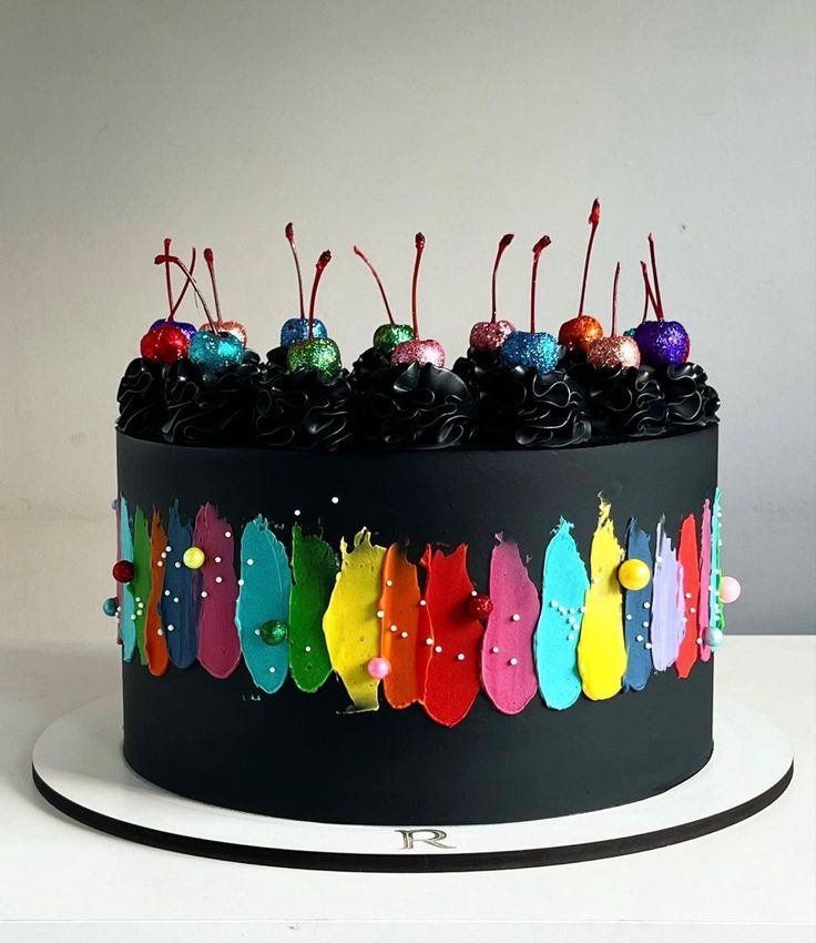 a black cake with colorful frosting and decorations