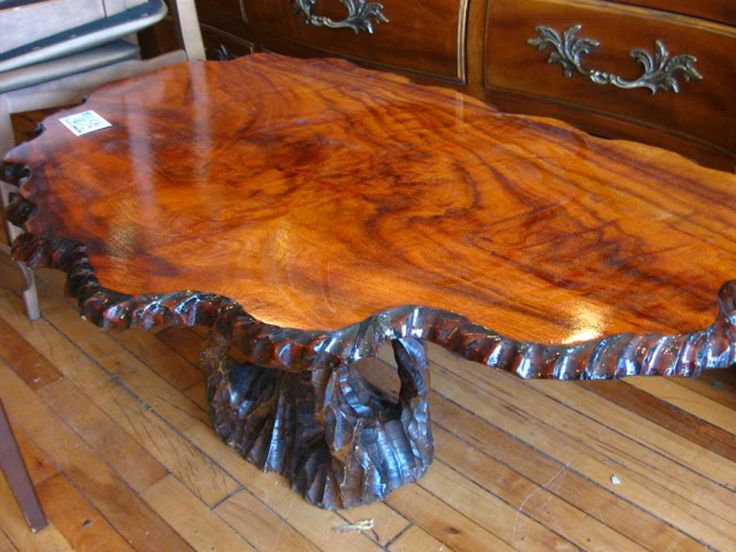 a large wooden table sitting on top of a hard wood floor next to a dresser