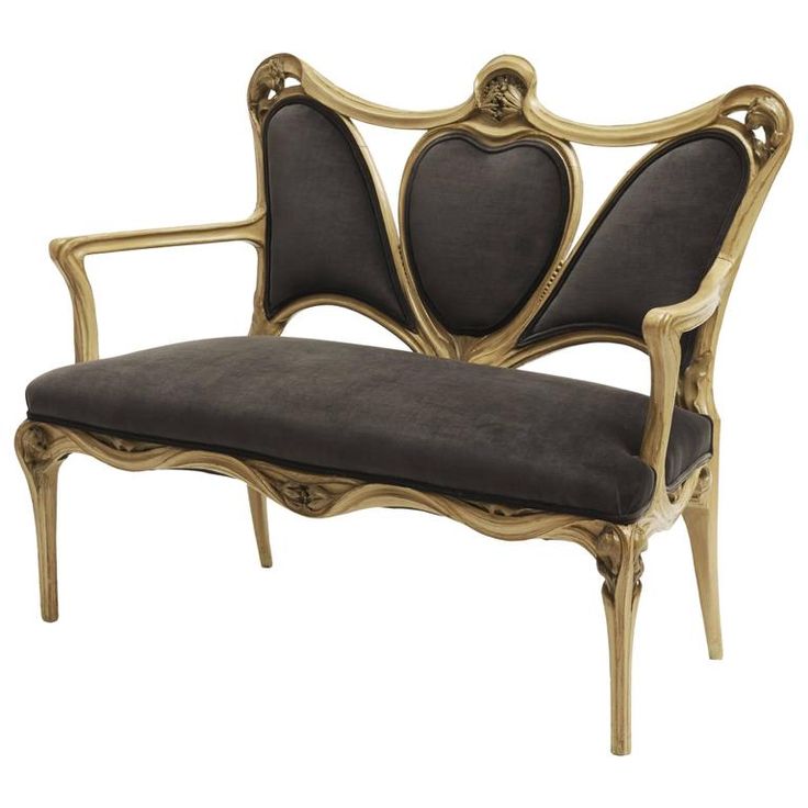 an antique style chair with black upholstered seat and gold trimmings on the back