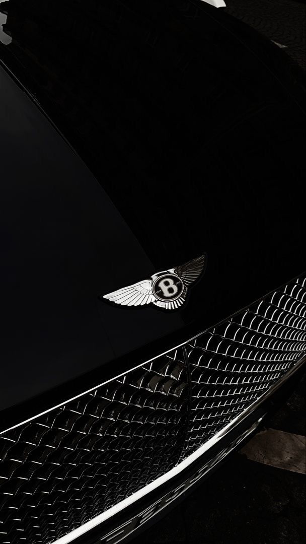 the front end of a black car with a bentley emblem on it's grill