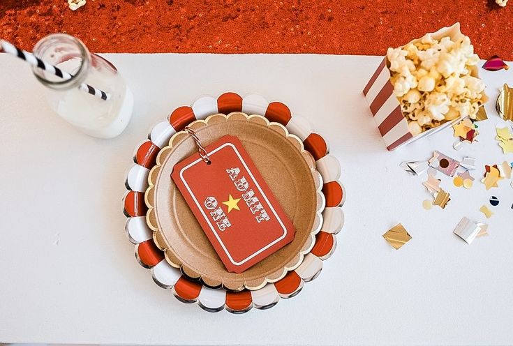 a plate with a red tag sitting on top of it next to a bowl of popcorn