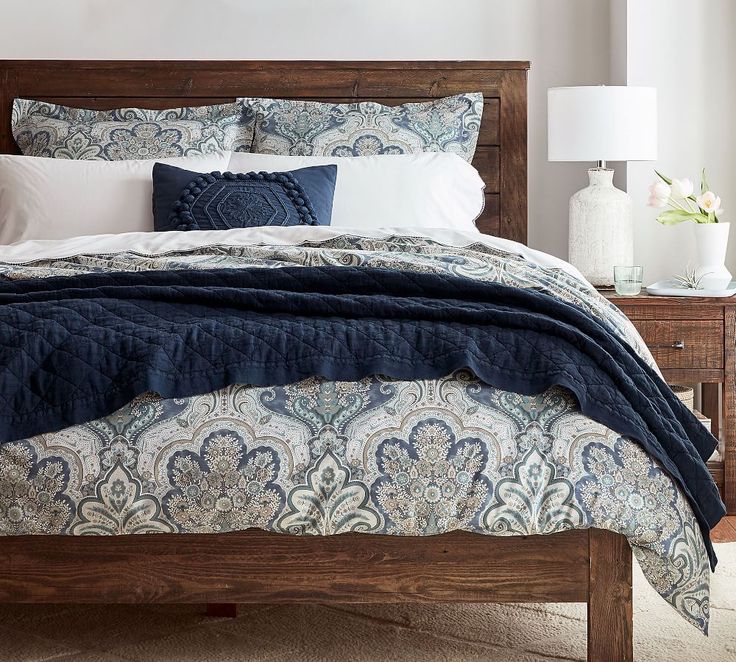 a bed with blue and white comforter in a bedroom