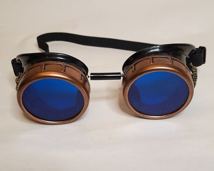 Atomic Goggles Exclusive Steampunk Collection We have for you a on-of-a-kind pair of beautifully handmade optic-conductors specifically designed for your time-traveling needs. Our goggles are for anyone who needs eye protection during space travel or even time-travel. They're also perfect for... Cosplay - Costumes - LARP - Festivals - Raves - Concerts and MORE! We share with you this pair of Steampunk Post-Apocalyptic Optic-Conductors from our personal vault. This wonderful pair of goggles is th Novelty Blue Adjustable Costume Accessories, Adjustable Blue Costume Accessories For Costume Party, Blue Adjustable Novelty Costume Accessories, Blue Novelty Costume Accessories Adjustable, Adjustable Blue Costume Accessories For Cosplay, Blue Novelty Costume Accessories For Cosplay, Aviator Goggles, Steampunk Goggles, Victorian Steampunk