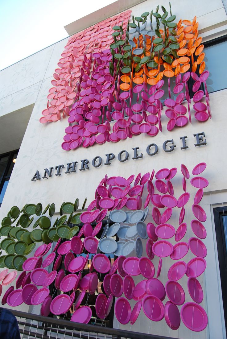 the front of an anthropologie store with pink and orange flowers on it