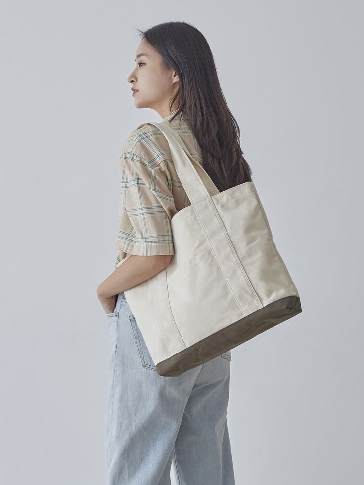 a woman carrying a white tote bag