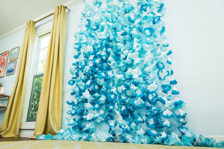 a blue and white christmas tree in the corner of a room with curtains on both sides