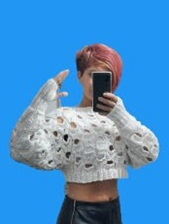 a woman with pink hair is taking a selfie in front of a blue background