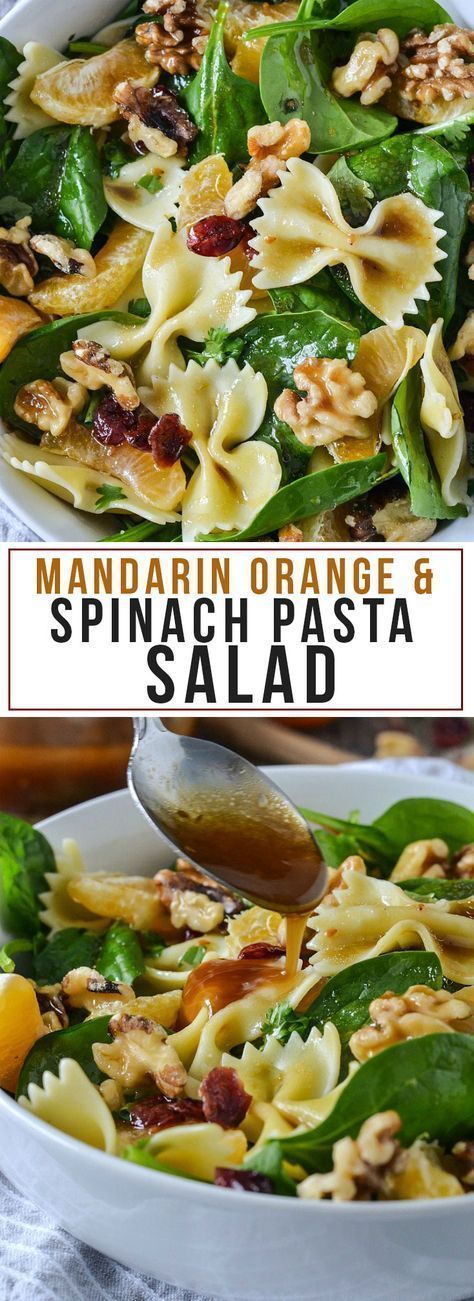 spinach pasta salad with oranges and nuts in a white bowl