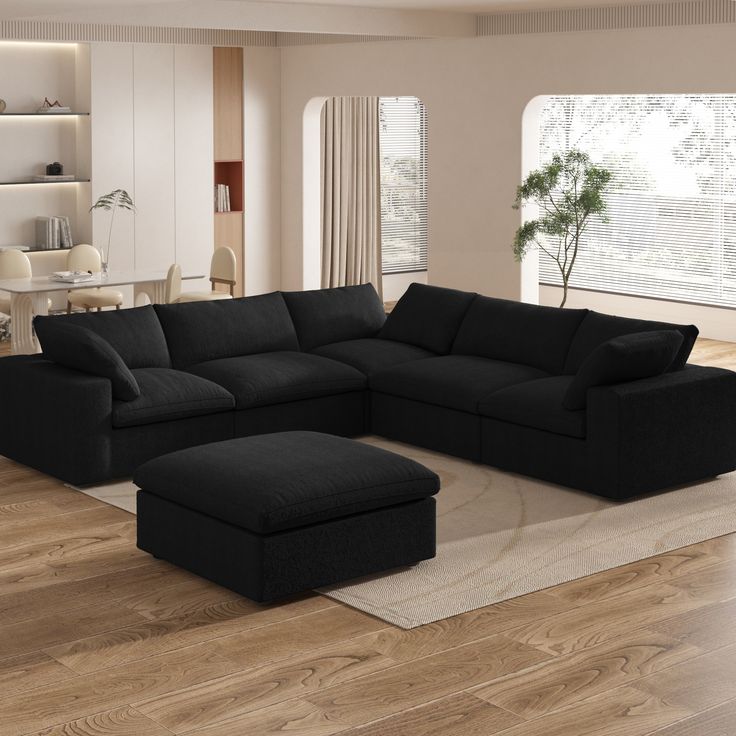 a living room with a black couch and ottoman