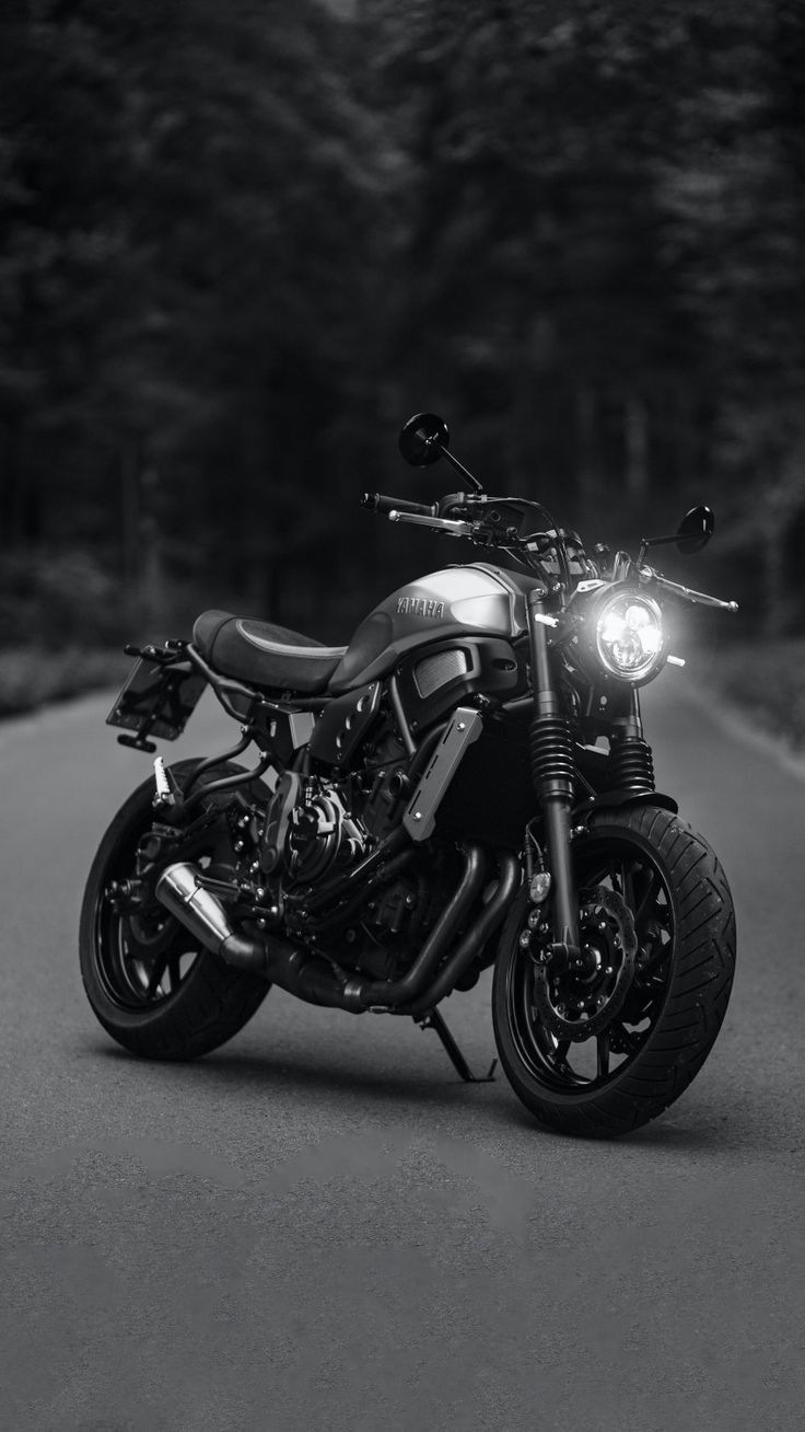 a black and white photo of a motorcycle on the road