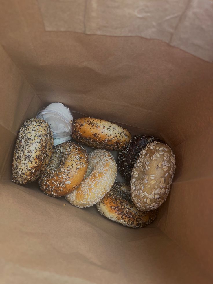 a brown bag filled with lots of different types of doughnuts