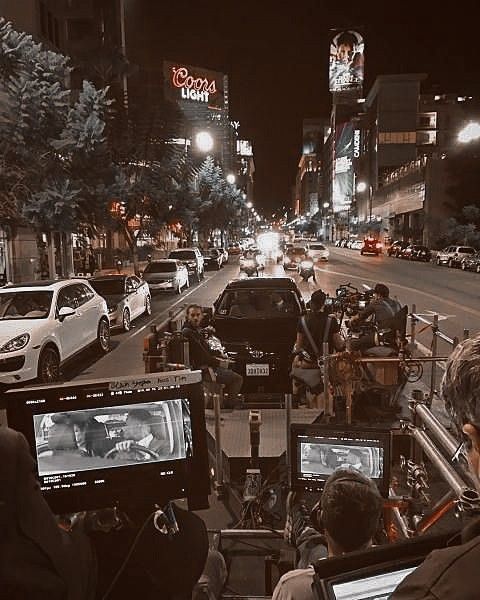 a city street filled with lots of traffic and people on the side of the road