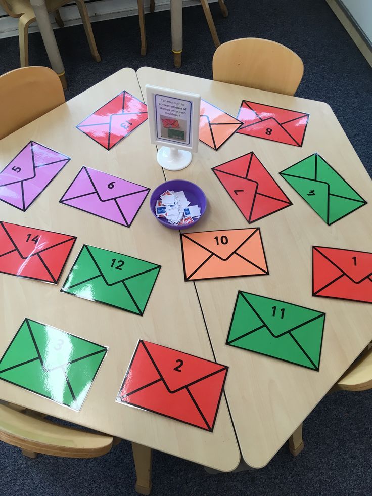 a wooden table topped with lots of different colored envelopes