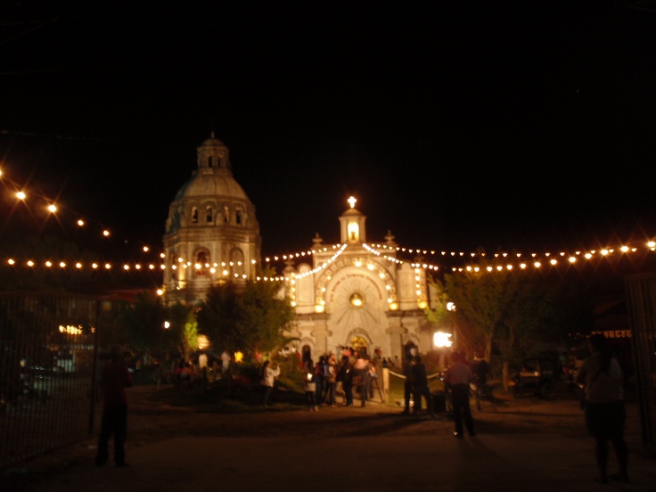 people are standing in front of a church at night