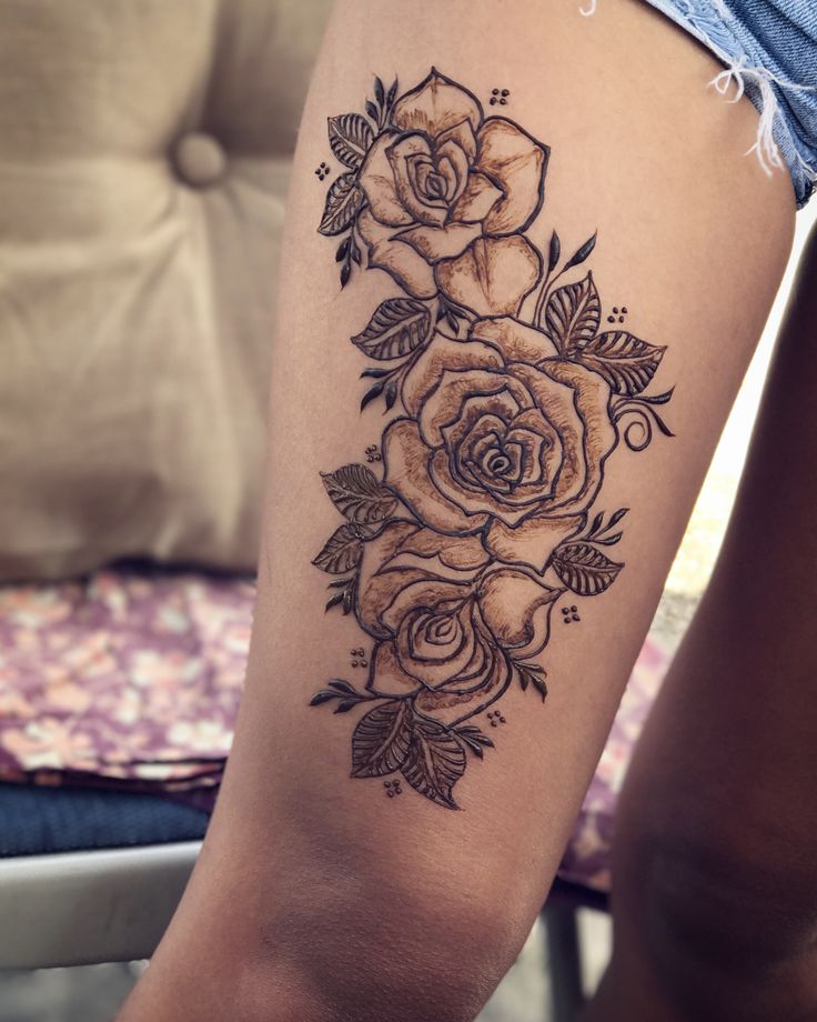 a woman's leg with a rose tattoo on it