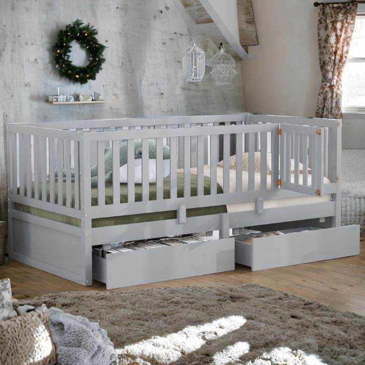 a white crib with drawers underneath it in a room next to a bed and rug