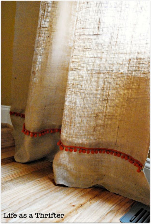 a curtain with red trim on it sitting next to a window