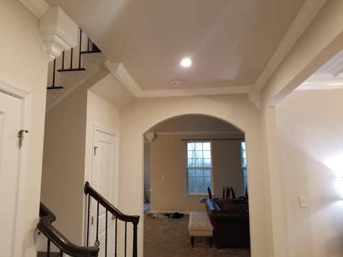 an entry way leading to a living room and dining room in a house with white walls