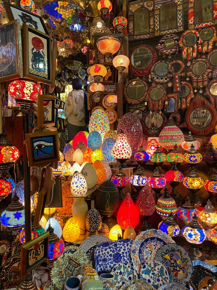 there are many colorful lights on display in this shop, and one person is looking at them