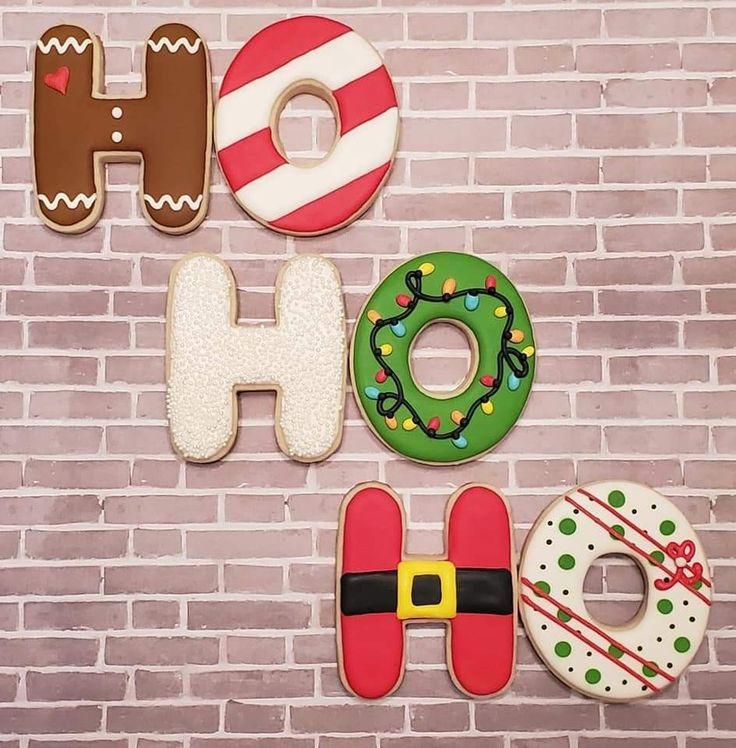 decorated christmas cookies are arranged in the shape of letters and numbers on a brick wall