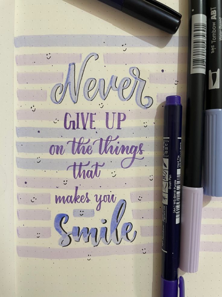 a notepad with some writing on it next to two pens and a marker that says never give up on the things that makes you smile