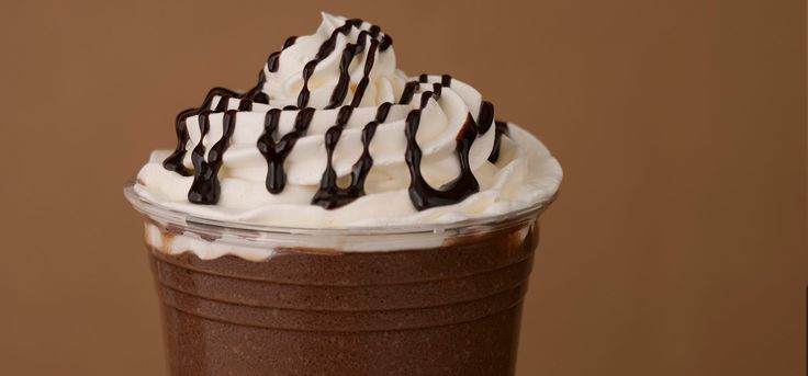 a chocolate drink with whipped cream and chocolate drizzles on it's top