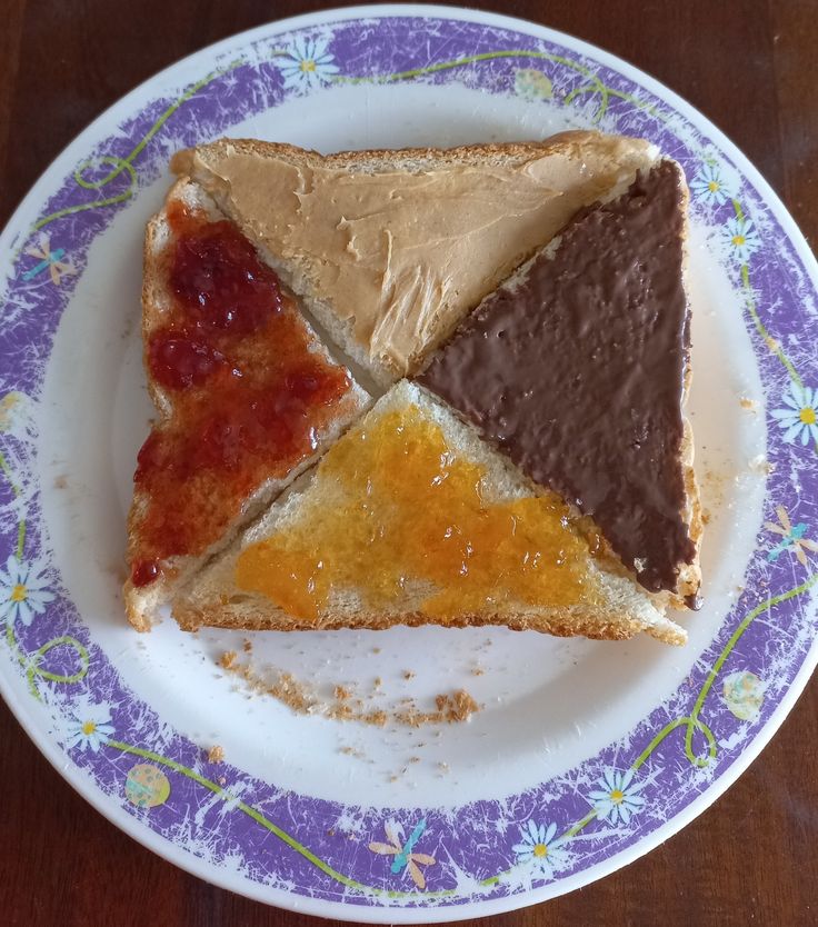 three slices of peanut butter, jelly and jelly cheesecake on a purple and white plate