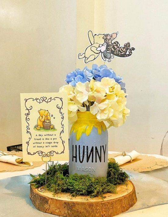 there is a vase with flowers in it on top of a wooden stand next to a card