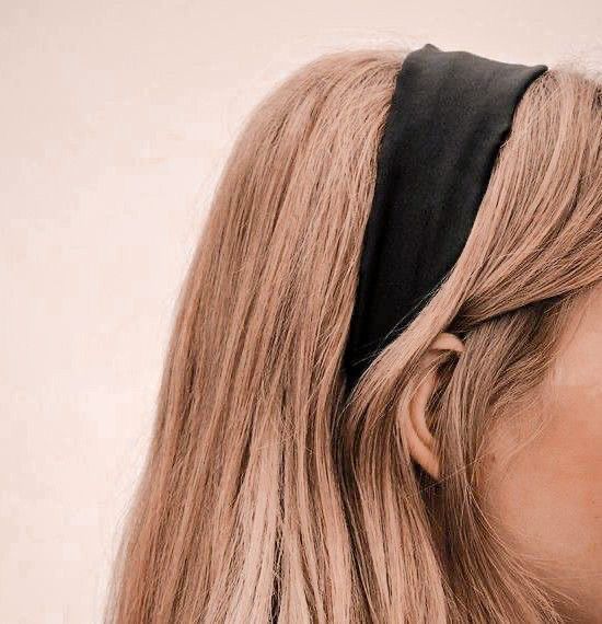 a woman with long blonde hair wearing a black headband