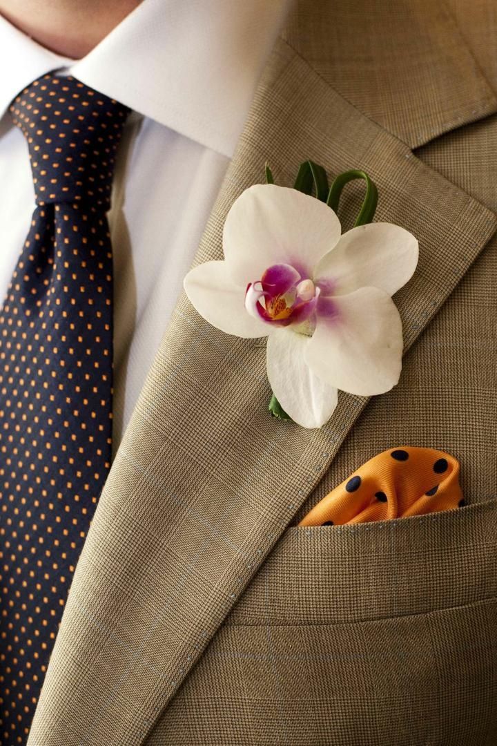 a man wearing a suit and tie with a flower in his lapel pocket,