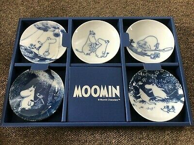 four blue and white plates in a box with the words moomin on them