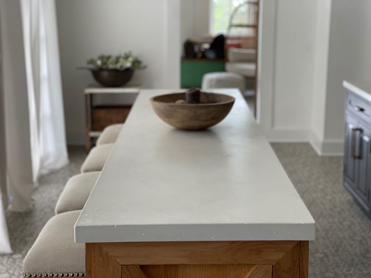 a bowl sitting on top of a white counter in a living room next to a couch