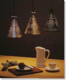 three lights hanging from the ceiling above a table with coffee cups and saucers on it