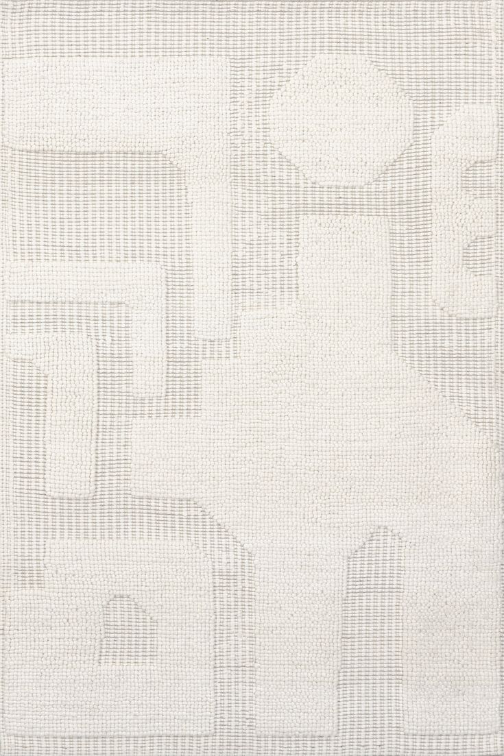 a white rug with an abstract design on it's side, in the shape of squares and rectangles