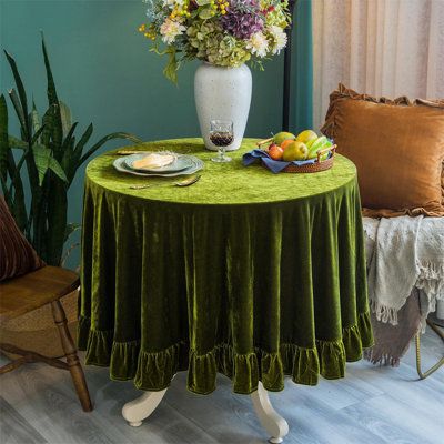 a green table cloth with flowers and fruit on it