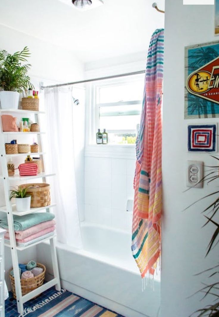 a bathroom with a bathtub, shower curtain and towels on the shelf next to it