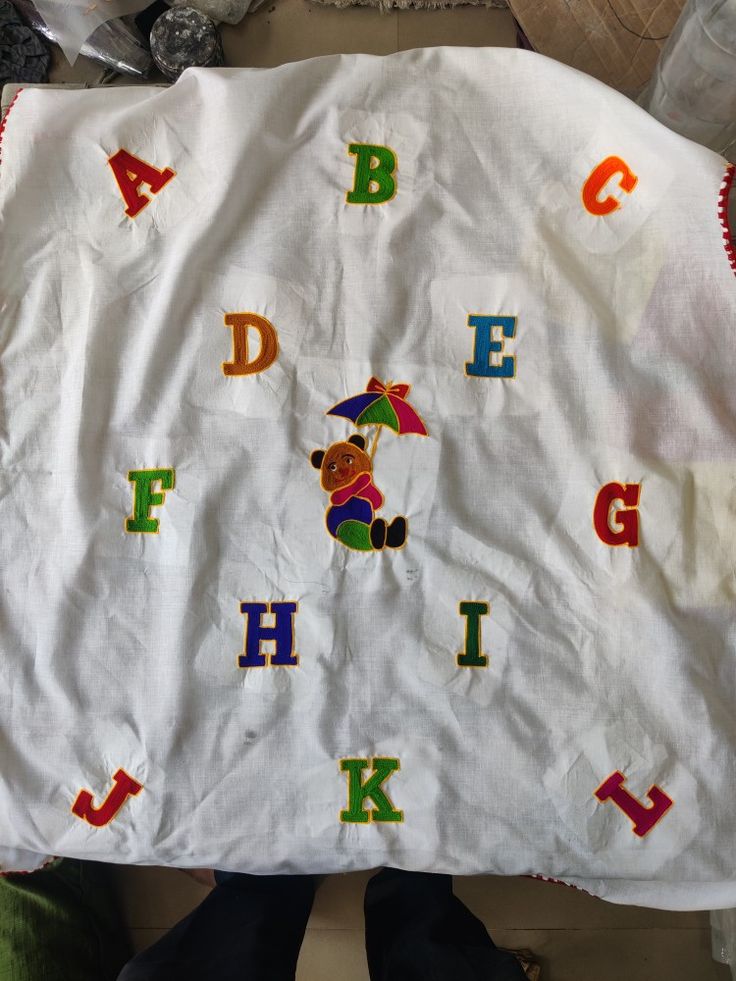 a child's blanket with the letters and animals on it, including an umbrella