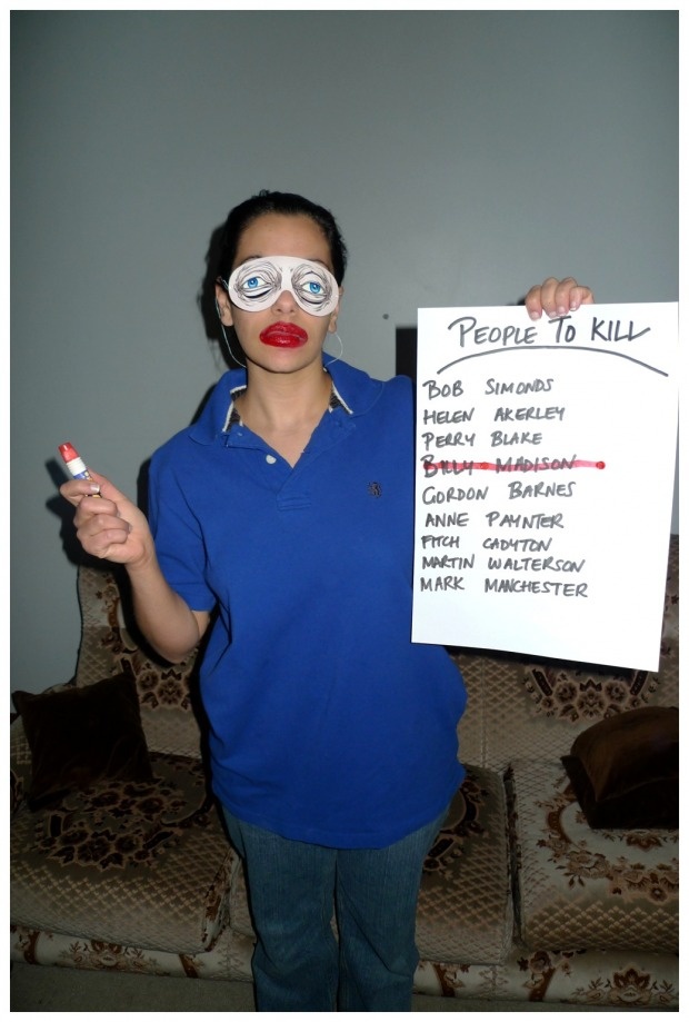 a woman holding up a sign that says people to kill and glasses on her face