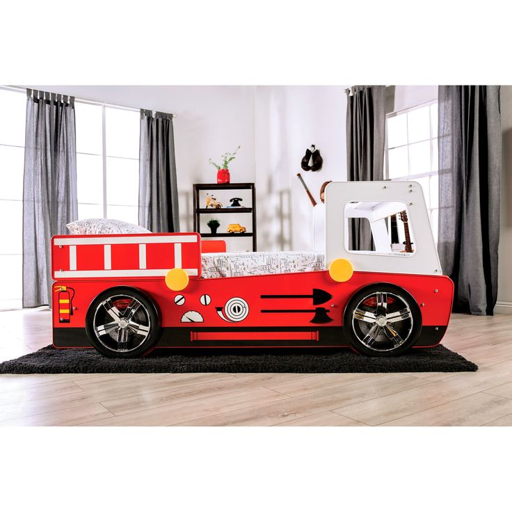 a child's firetruck bed in a room