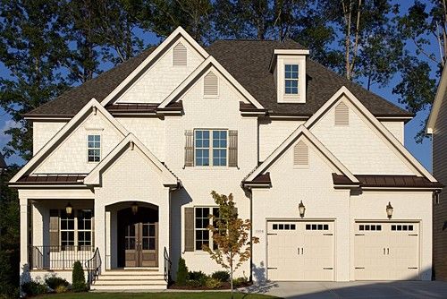 a large white house with two garage doors