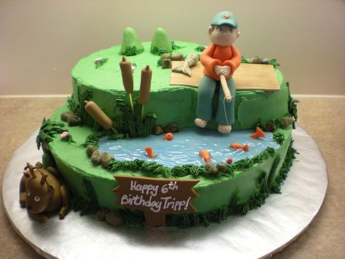 a birthday cake with a man sitting on top of a pond and holding a fishing rod