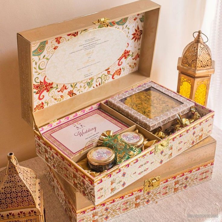 an open wooden box filled with assorted items on top of a white tablecloth