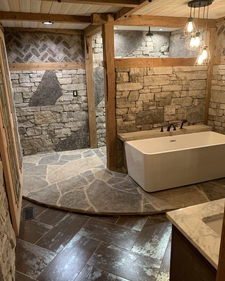 a bathroom with stone walls and flooring in the shower area, along with a large bathtub