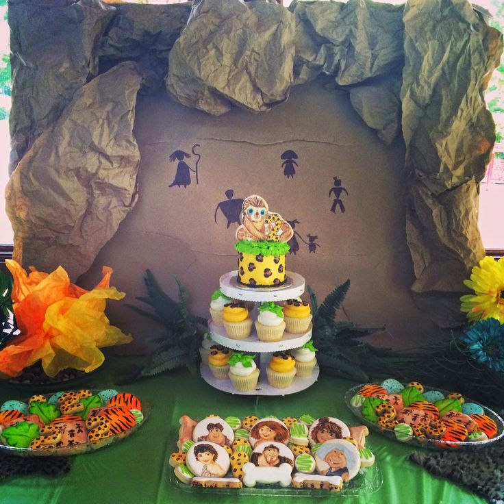 a jungle themed dessert table with cupcakes, cookies and other treats on it