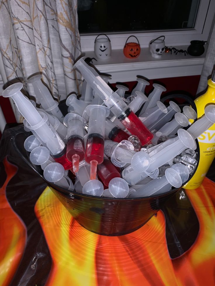 a bowl filled with lots of plastic bottles on top of a table next to a window