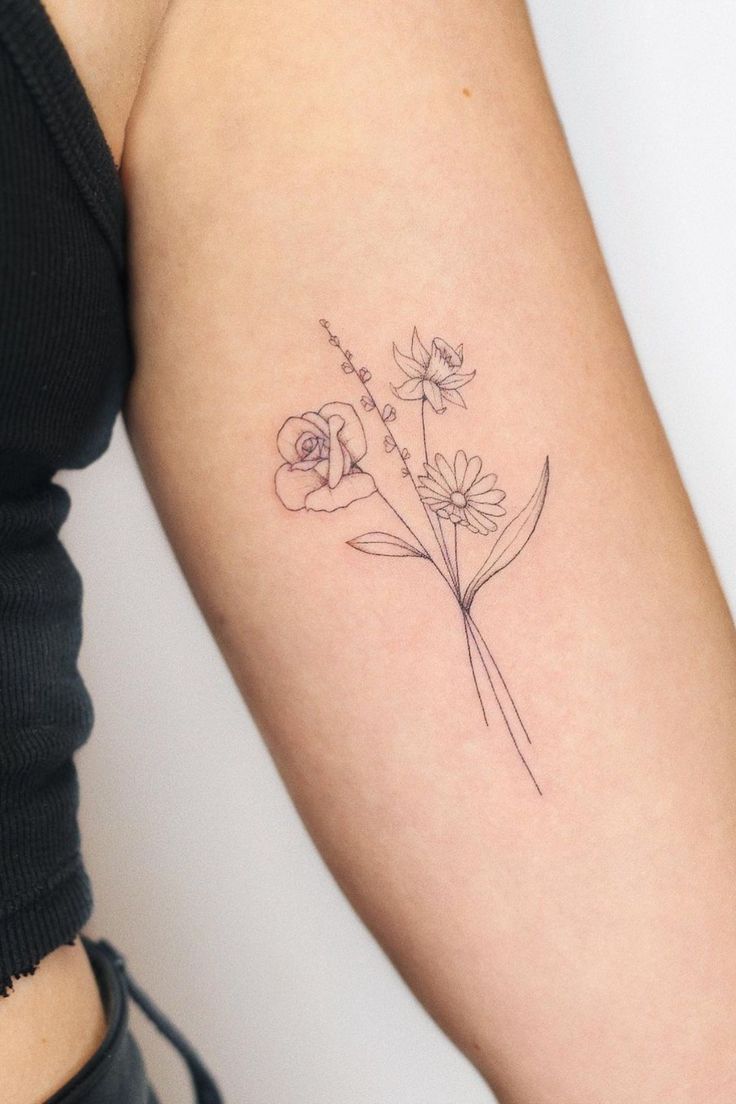 a woman's arm with a flower tattoo on the left side of her arm